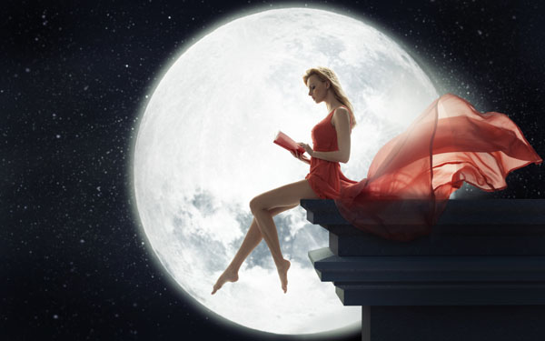 月夜に屋根で本を読む女性